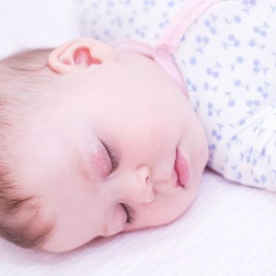 Close up of a babies head whilst they are asleep.